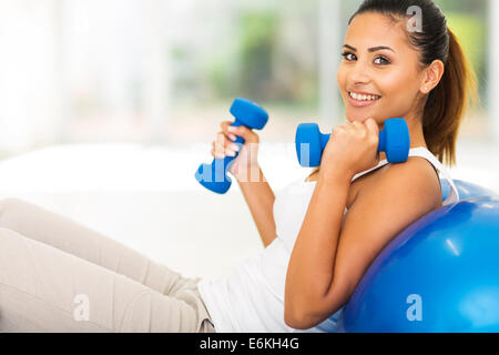 Bella giovane donna facendo esercizio di fitness in casa Foto Stock