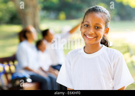 Bellissimo Indian bambina in piedi nella parte anteriore della famiglia all'aperto Foto Stock