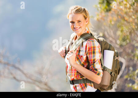 Felice giovane donna in piedi con zaino in piedi sulla cima della montagna Foto Stock