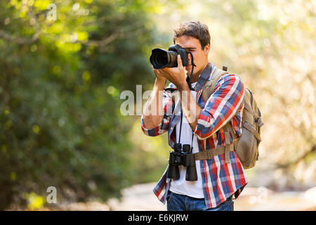Giovane fotografo Scattare foto nella valle di montagna Foto Stock