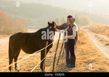 Bella giovane petting cavallo al ranch Foto Stock