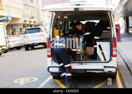 I paramedici offload della paziente da un'ambulanza Foto Stock