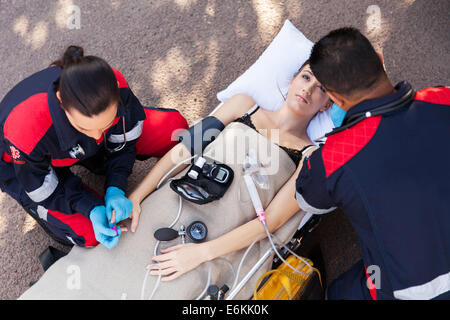 Al di sopra di vista del team paramedico esame paziente Foto Stock