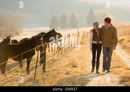 Giovani coppie romantiche passeggiate a cavallo fattoria Foto Stock