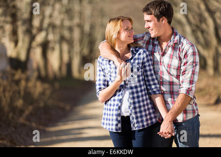 Sorridente coppia giovane passeggiate in campagna autunno Foto Stock