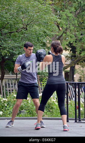 Un giovane uomo e giovane donna a un esercizio di inscatolamento classe in Washington Square Park nel Greenwich Village di New York City. Foto Stock