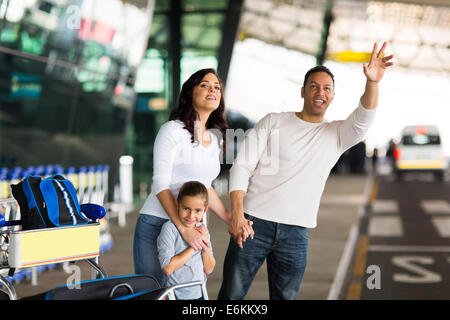 Uomo bello e la sua famiglia salutando taxi dall aeroporto Foto Stock