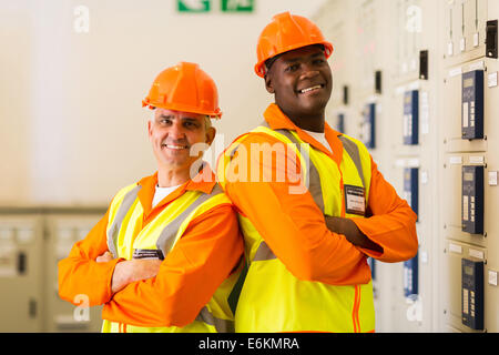 Ritratto di bello ingegneri industriali con le braccia incrociate in power plant sala di controllo Foto Stock