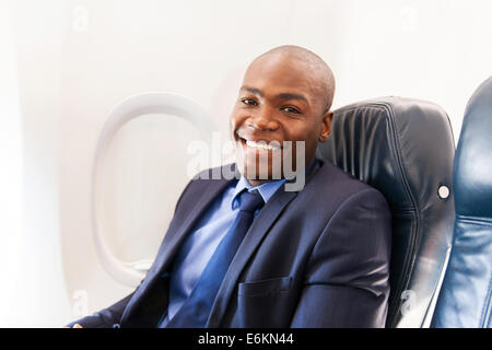 Sorridente americano africano passeggero aereo rilassante durante il volo Foto Stock