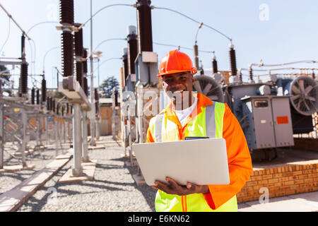 Africa professionale Ingegnere elettrico utilizzando il computer portatile nella sottostazione Foto Stock