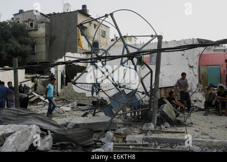 Rafah nella striscia di Gaza, Territori palestinesi. 26 Ago, 2014. Bambini palestinesi gioco intorno a un distrutto mini ruota panoramica nei pressi dei resti di case che sono state distrutte da un attacco aereo israeliano a Rafah cittadina nel sud della striscia di Gaza il 26 agosto 2014. Fuoco israeliano uccisi 10 palestinesi di fronte a Gaza il 25 agosto, mentre l'Egitto ha proposto un nuovo cessate il fuoco che avrebbe aperto passaggi chiave nel territorio bloccato. Credito: ZUMA Press, Inc./Alamy Live News Foto Stock