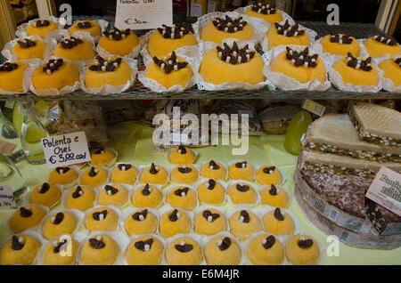 Polenta e Osei la pasta sulla visualizzazione in negozio, riempiti con marmellata di albicocche e laminati in zucchero. Bergamo, regione Lombardia, Italia settentrionale. Foto Stock