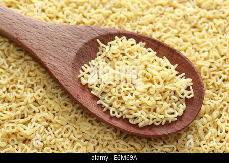 Materie Minestrone di pasta in un cucchiaio di legno su un minestrone di pasta dello sfondo. Foto Stock