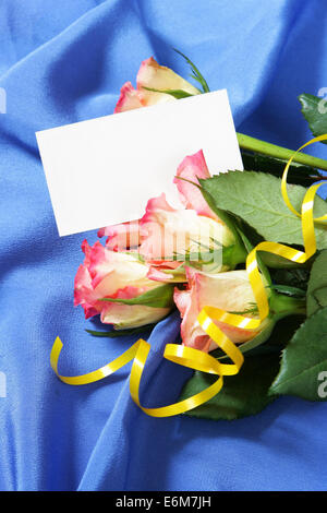 Le rose su seta blu con sfondo bianco biglietto da visita per il proprio testo Foto Stock
