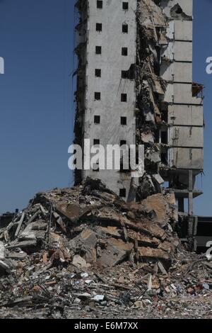 La città di Gaza, Striscia di Gaza, Territori palestinesi. Xviii Nov, 2013. Una vista generale dei resti di uno di Gaza appartamento più alte torri, che testimoni ha detto è stato colpito da un attacco aereo israeliano che ha distrutto gran parte di essa, nella Striscia di Gaza City il 26 agosto 2014. Incursioni aeree israeliane lanciate prima dell'alba il martedì hanno ucciso due palestinesi e distrutto gran parte di uno di Gaza più alti appartamento e edifici per uffici, l'impostazione off grandi esplosioni e ferendone venti persone, sanità palestinese hanno detto i funzionari. Israele ha avuto un immediato commentare gli attentati che hanno avuto luogo come mediatori egiziano intensificato gli sforzi per conseguire Foto Stock