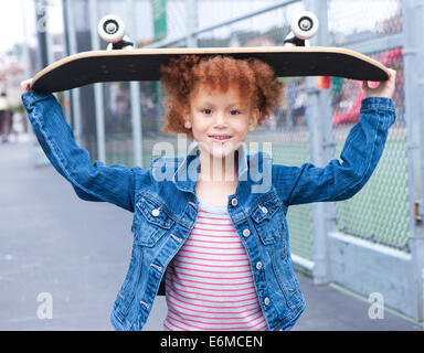 Ritratto di ragazza (4-5) azienda skateboard Foto Stock