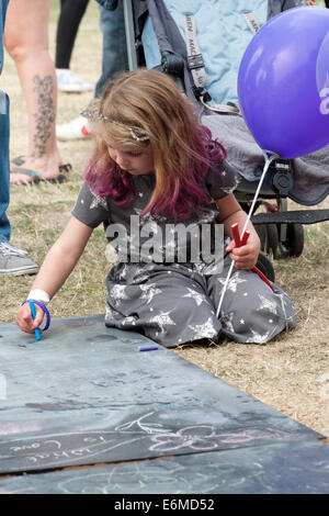 Bambina scrivendo commenti su una scheda di gesso in una fase di stallo presso il festival di vittoriosa 2014 southsea England Regno Unito Foto Stock