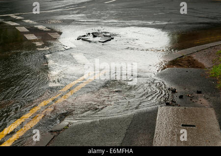 Perde acqua da una raffica di acqua nella principale strada Foto Stock