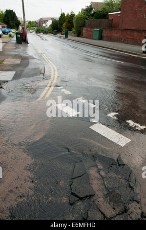 Perde acqua da una raffica di acqua nella principale strada Foto Stock