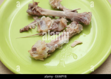 Mangiato le cosce di pollo su una piastra. Foto Stock