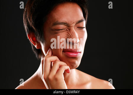 Ritratto di un giovane uomo asiatico con il mal di denti Foto Stock
