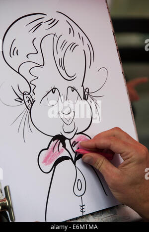 Un artista il disegno di una caricatura sul Royal Mile di Edimburgo. Foto Stock