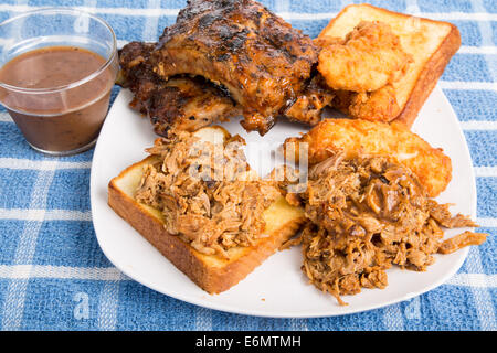 Piastra barbecue con carne di maiale tritata sandwich, rack di nervature e le dita di pollo Foto Stock