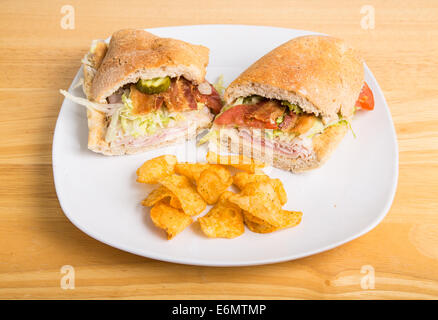 Una fresca, sandwich secondario su una piastra con patate fritte Foto Stock