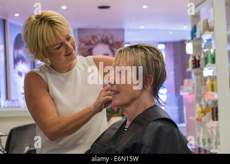 Donna anziana IN PARRUCCHIERE avente taglio di capelli e disegnato da parrucchiere. Inghilterra, Regno Unito Foto Stock