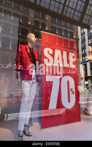 Store finestre visualizzando il 70% di sconto vendita segno nella città di New York Foto Stock