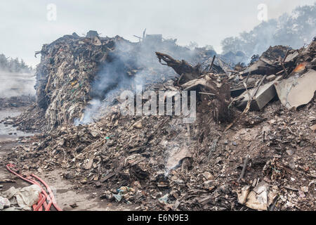 Marshgate, Swindon, Wiltshire, Regno Unito. Il 27 agosto 2014. Il cumulo di rifiuti al riciclaggio Averies che è stata a covare dal 21 luglio 2014 viene ora affrontata da vigili del fuoco da Swindon, Marlborough, Royal Wooton Bassett e altrove nel Wiltshire. Fotografia Credito: 2014 John Henshall / Alamy Live News. JMH6380 Foto Stock