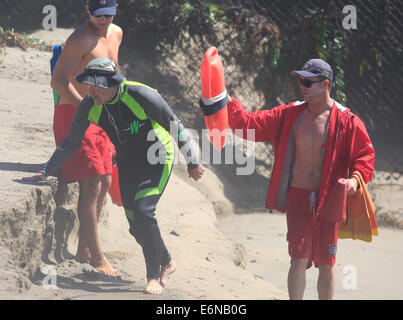 Malibu, California, USA. Il 27 agosto, 2014. Bagnini di assistere un surfista in Malibu a Surfrider beach come grandi onde gonfiata dall uragano distanti Marie arriva a dalle spiagge della California del Sud. Credito: ZUMA Press, Inc./Alamy Live News Foto Stock