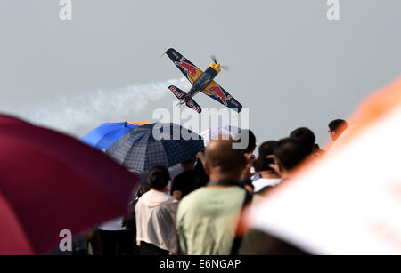 (140828) -- FAKU, Agosto 28, 2014 (Xinhua) -- un piano della Red Bull Aerobatic Team vola in un air show in Faku, a nord-est della Cina di Provincia di Liaoning, Agosto 27, 2014. La Red Bull il team acrobatico della Cina, la nazione del primo numero illimitato di acrobazia team, è stata fondata dal pilota professionista Zhao Wei sulla sett. 20 del 2013. Oltre a Zhao, i membri del team sono tutti dal Sud Africa. Il team ha quattro XA 42 aerei, il top-level aerobatic piani che consentono ad un pilota di volare molto ad altitudini più basse e velocità più lente e quindi forniscono un più forte impatto visivo per gli spettatori. Il team acrobatico preparin è Foto Stock