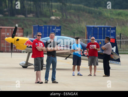 (140828) -- FAKU, Agosto 28, 2014 (Xinhua) -- i membri della Red Bull Team acrobatico cinese di comunicare con un pilota (2 L) in Faku, a nord-est della Cina di Provincia di Liaoning, Agosto 25, 2014. La Red Bull il team acrobatico della Cina, la nazione del primo numero illimitato di acrobazia team, è stata fondata dal pilota professionista Zhao Wei sulla sett. 20 del 2013. Oltre a Zhao, i membri del team sono tutti dal Sud Africa. Il team ha quattro XA 42 aerei, il top-level aerobatic piani che consentono ad un pilota di volare molto ad altitudini più basse e velocità più lente e quindi forniscono un più forte impatto visivo per gli spettatori. Il aerob Foto Stock