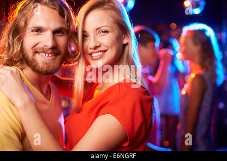 Felice giovani date guardando la fotocamera a parte nel night club Foto Stock