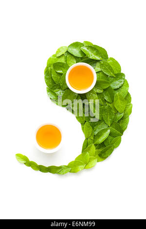 Tazze da tè e foglie in forma di Yin Yang simbolo Foto Stock