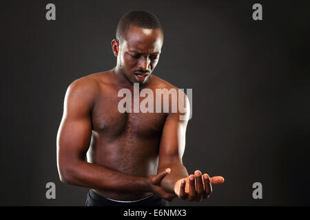 L'uomo africano impulso di controllo su sfondo nero Foto Stock