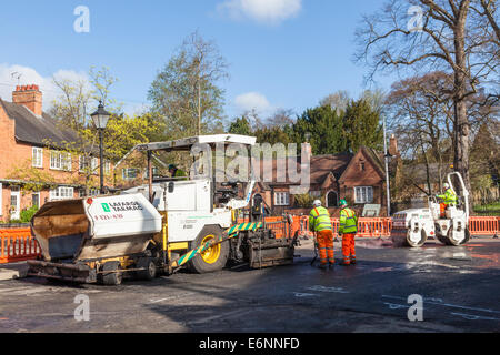I lavori di manutenzione stradale. Lastricatore, rullo su strada e la strada dei lavoratori sul rifacimento di strade in un villaggio street, Nottinghamshire, England, Regno Unito Foto Stock