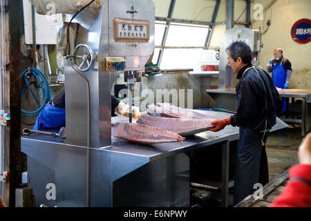 Il mercato del pesce di Tsukiji, Tokyo, Giappone, Asia, il più grande commercio all'ingrosso di mercato di pesce nel mondo. Tra uomini, lavoratori tonno di taglio Foto Stock