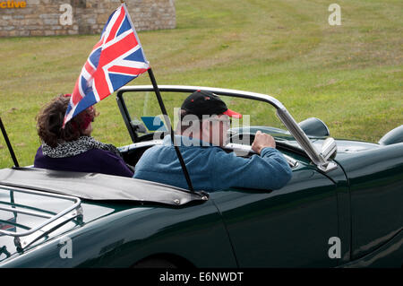 La gente in una Austin Healey Sprite auto su Fosse Way road, Warwickshire, Regno Unito Foto Stock