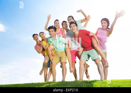 Foto di gruppo di allegro giovani adulti in piedi sull'erba Foto Stock