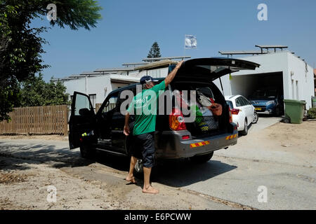 Netiv Haasara, Israele. 28 Agosto, 2014. I residenti locali di ritornare alla loro casa in Netiv Haasara in Israele, nel quartiere meridionale il 28 agosto 2014. In assenza di una soluzione tecnologica come ferro Dome, la relativamente semplice la malta è diventata HamasÕ più letale arma contro i civili della comunità israeliana vicino alla striscia di Gaza e come tale nel corso dei combattimenti con Hamas la maggior parte delle comunità lungo il confine sono stati quasi completamente evacuato. Credito: Eddie Gerald/Alamy Live News Foto Stock