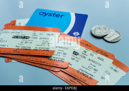 Una pila di biglietti ferroviari per il Regno Unito, insieme a una carta Oyster e due monete 10p in cambio. Foto Stock