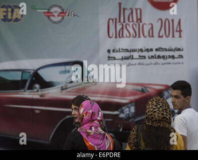 Tehran, Iran. 28 Agosto, 2014. Agosto 28, 2014 - Teheran, Iran - giovani iraniani sostare davanti a un banner mentre la visita dell'Iran Classica 2014 auto e moto visualizza in Tehran's Ararat complesso sportivo. Morteza Nikoubazl/ZUMAPRESS © Morteza Nikoubazl/ZUMA filo/Alamy Live News Foto Stock