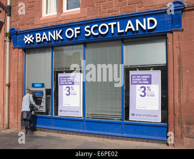 Donna prelevare denaro dal Bancomat presso la Banca di Scozia, Dunbar, East Lothian, Scozia, Europa Foto Stock
