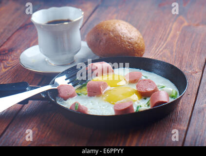 Uova fritte con salsicce e una tazza di caffè .prima colazione corso di laurea Foto Stock