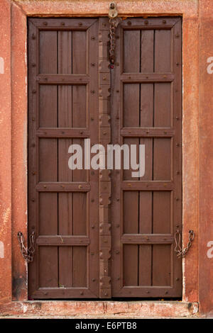 Verticale fino in prossimità della porta di legno con sculture ornamentali in Udaipur, Rajastan, India Foto Stock
