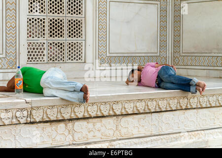 Due uomini dormono sui passi del Taj Mahal di Agra, India Foto Stock