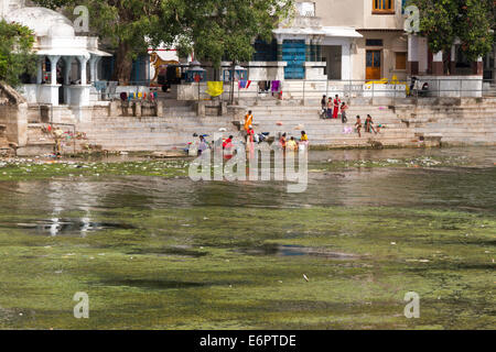 Le donne indiane la balneazione e il bucato sulle rive del lago Pichola in Udaipur, Rajastan, India Foto Stock