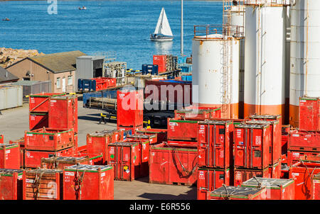 PETERHEAD HARBOUR ABERDEENSHIRE Scozia rosso in contenitori per il petrolio del Mare del Nord area di servizio e un yacht Foto Stock